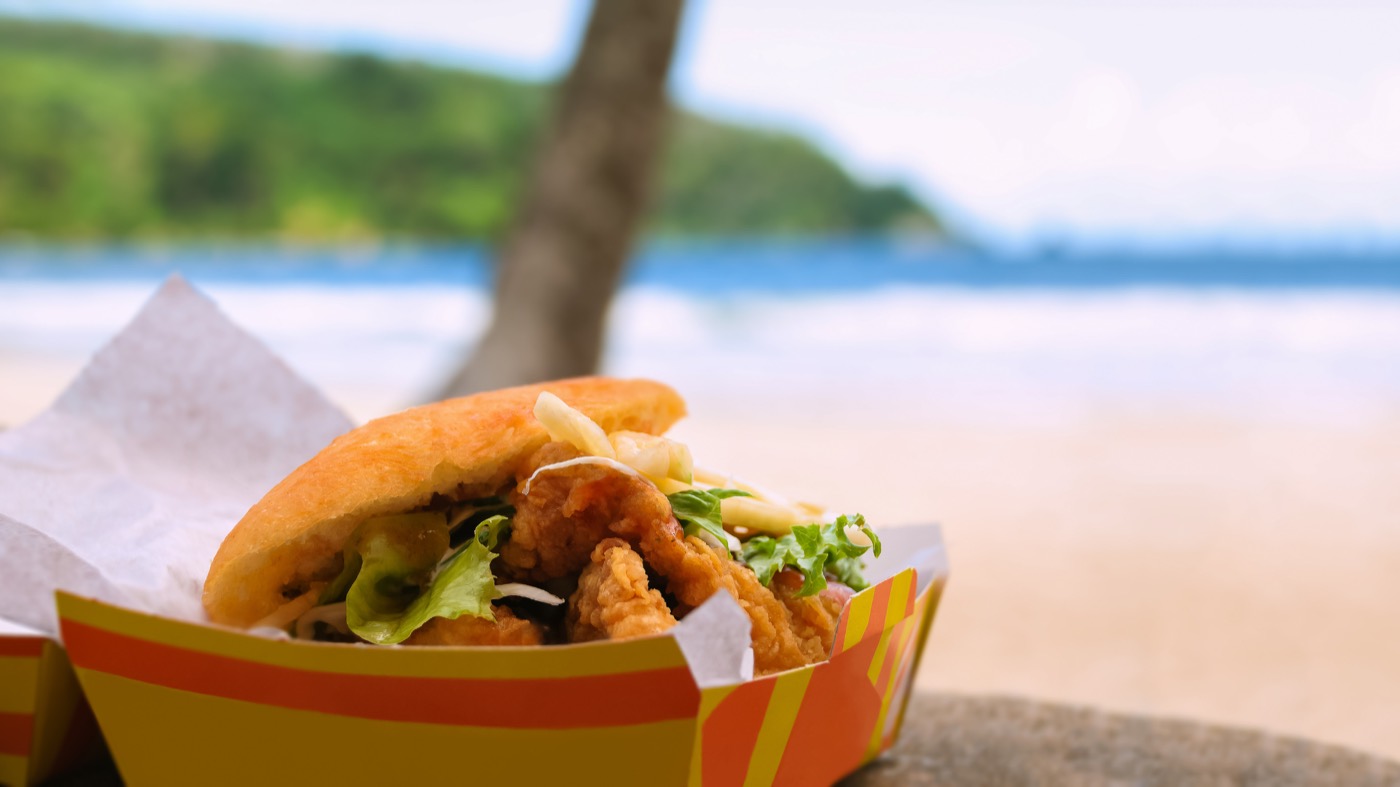 Bake and shark in a paper tray, Maracas Bay behind it
